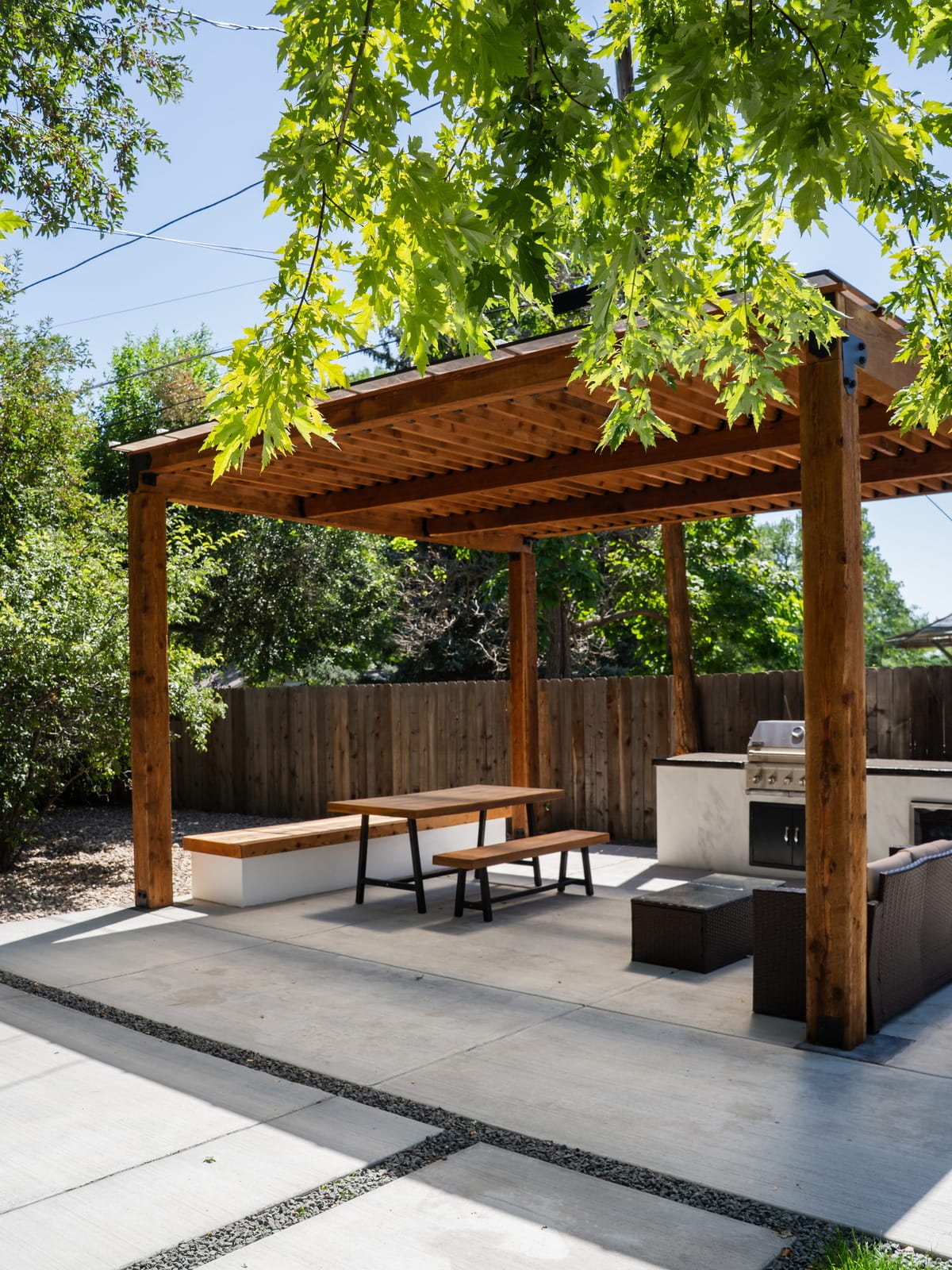 Cedar pergola with built-in outdoor kitchen and dining area