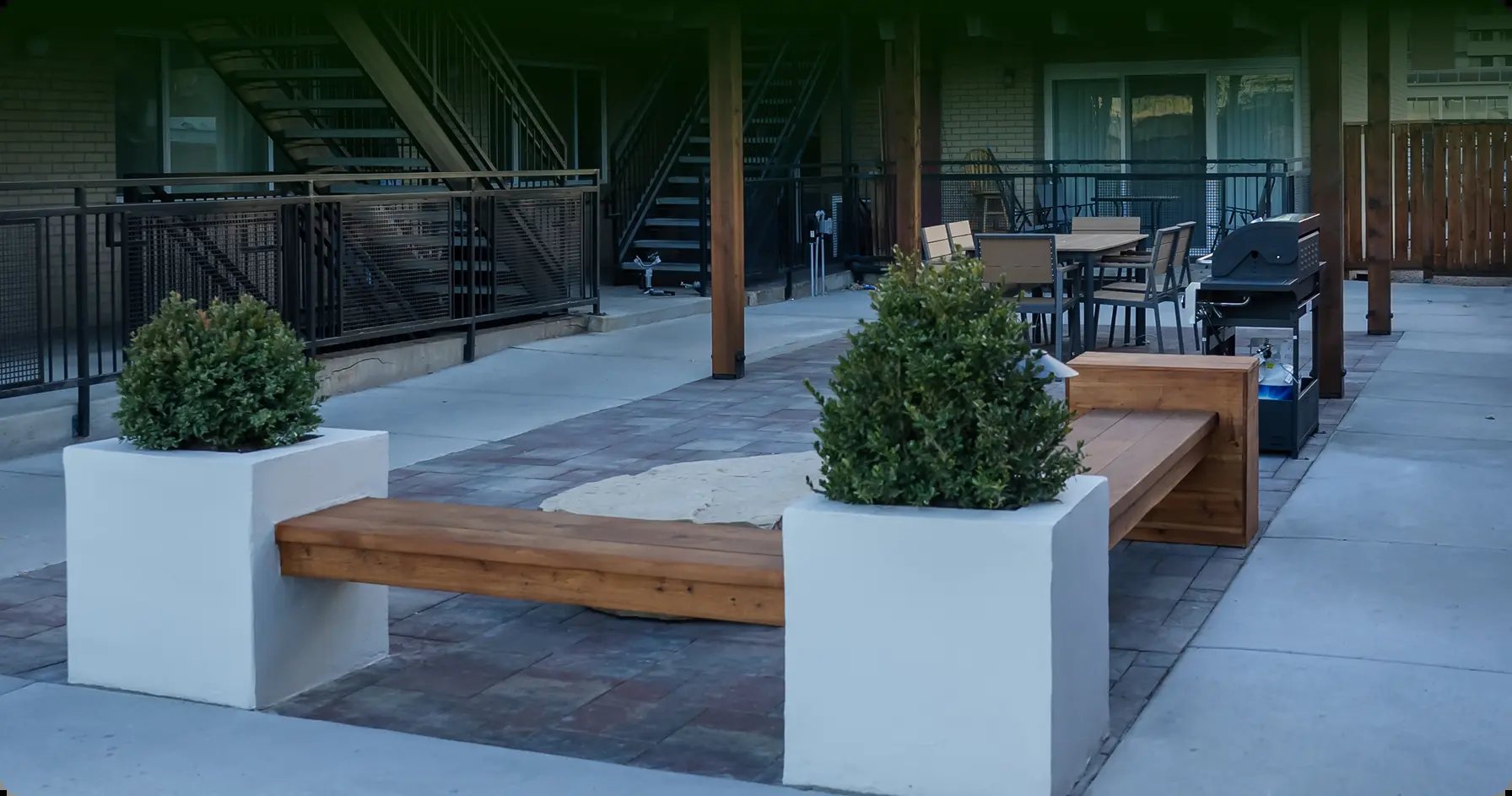 Finished commercial courtyard with hardscape, planters and custom bench seating